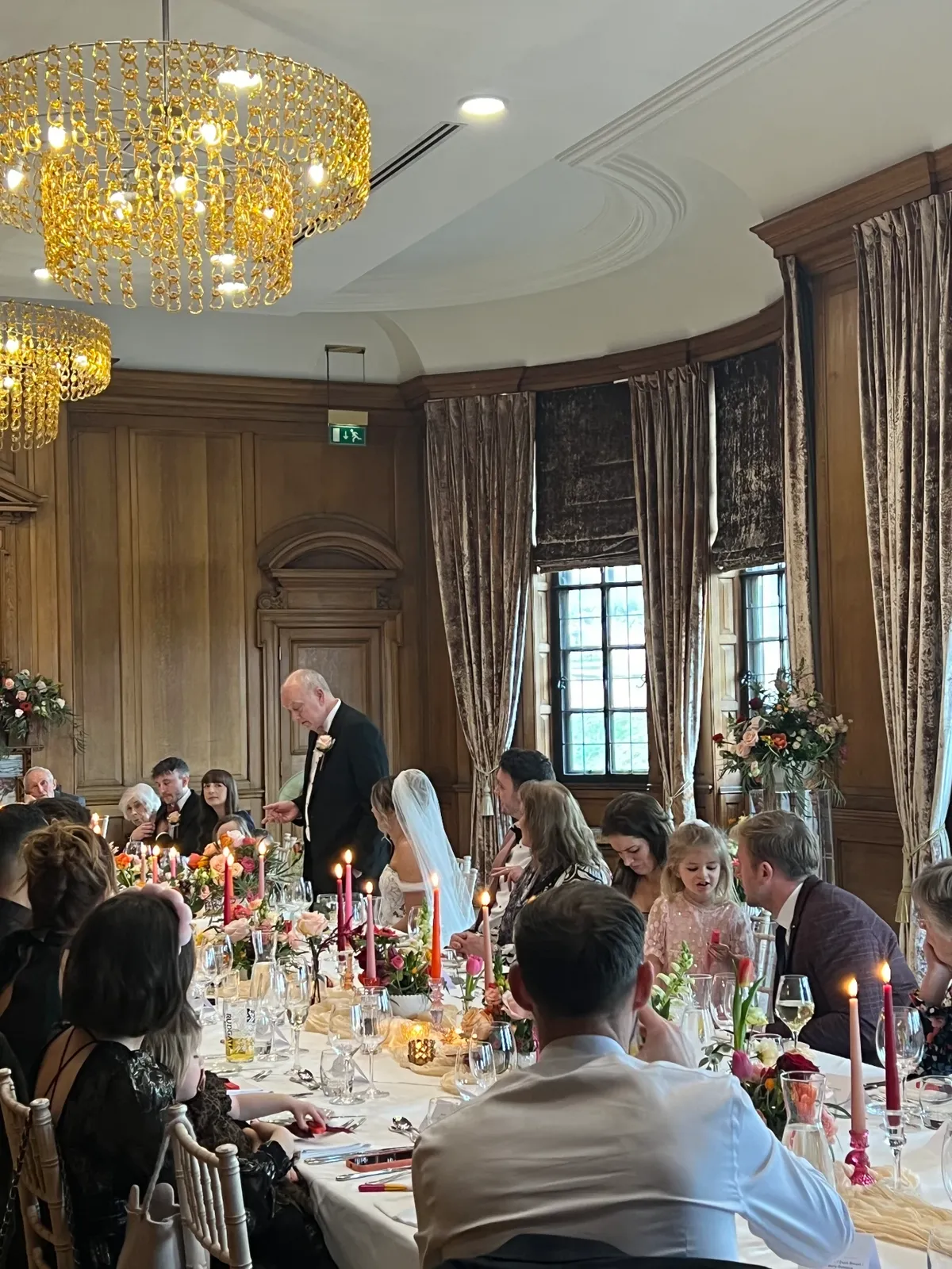 Candlelit wedding breakfast during the speeches in a panelled room