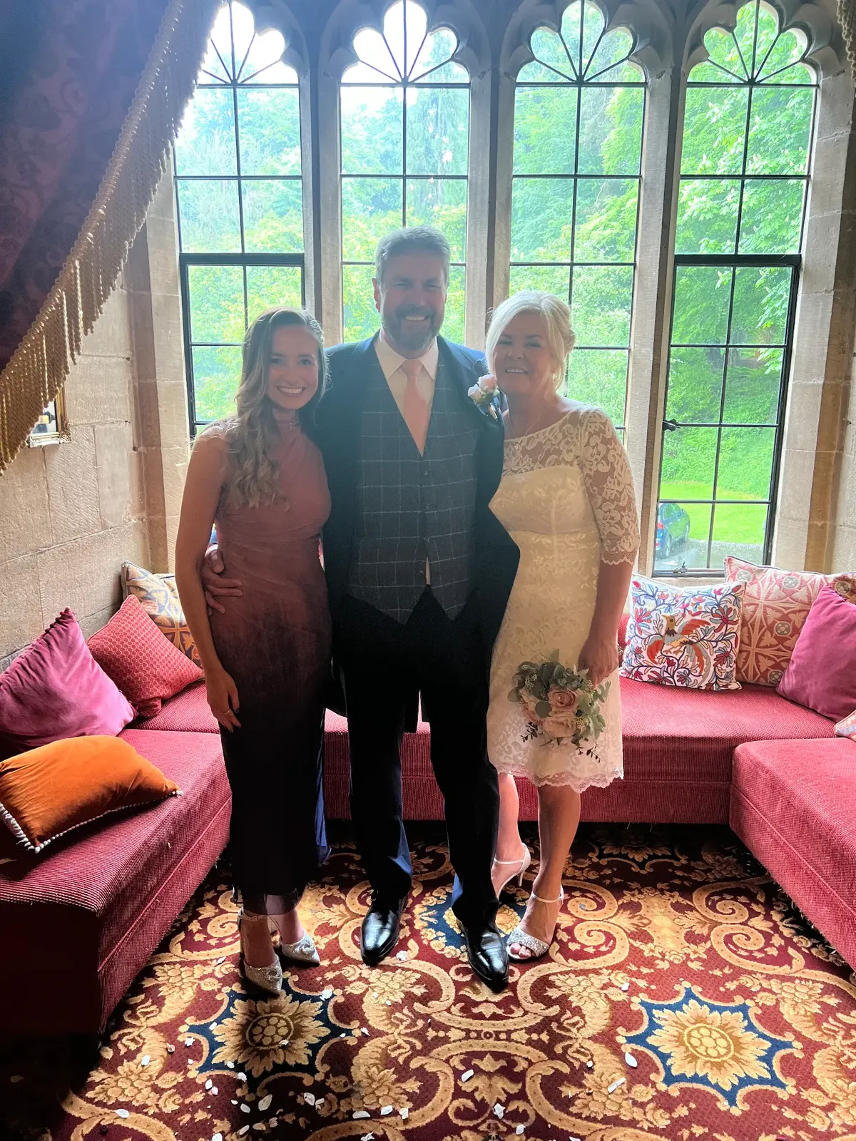 Sally Hall with a bride and groom by gothic castle windows