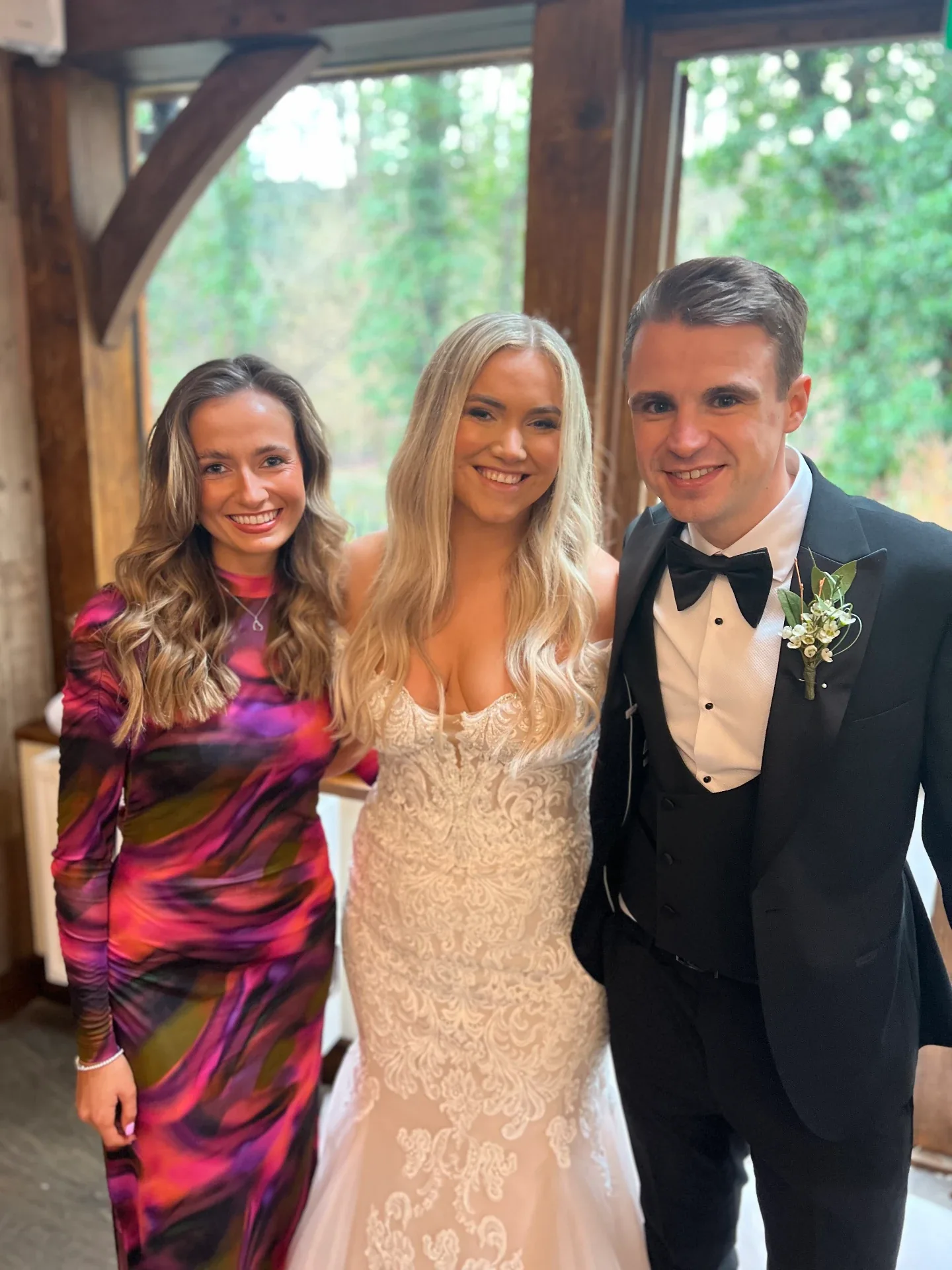 A singer with the bride and groom at their barn wedding