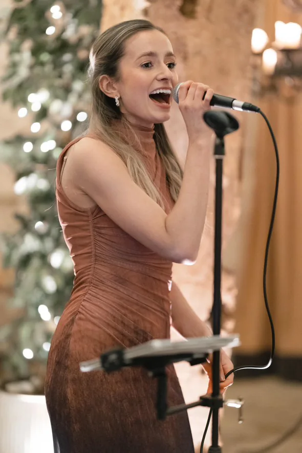 Sally Hall singing beside candlelight at a wedding