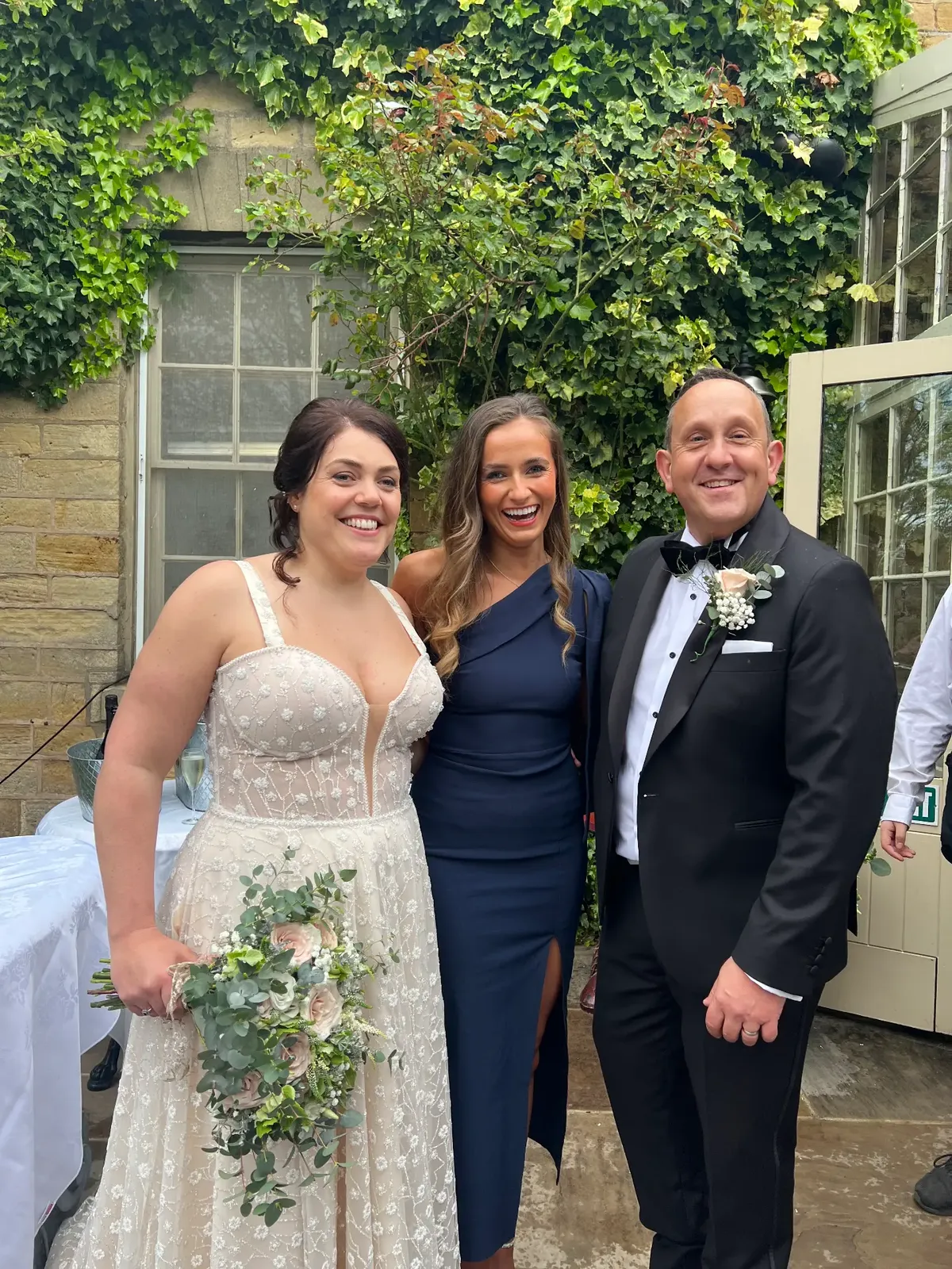 Sally Hall with a bride and groom beneath ivy at Crab Manor
