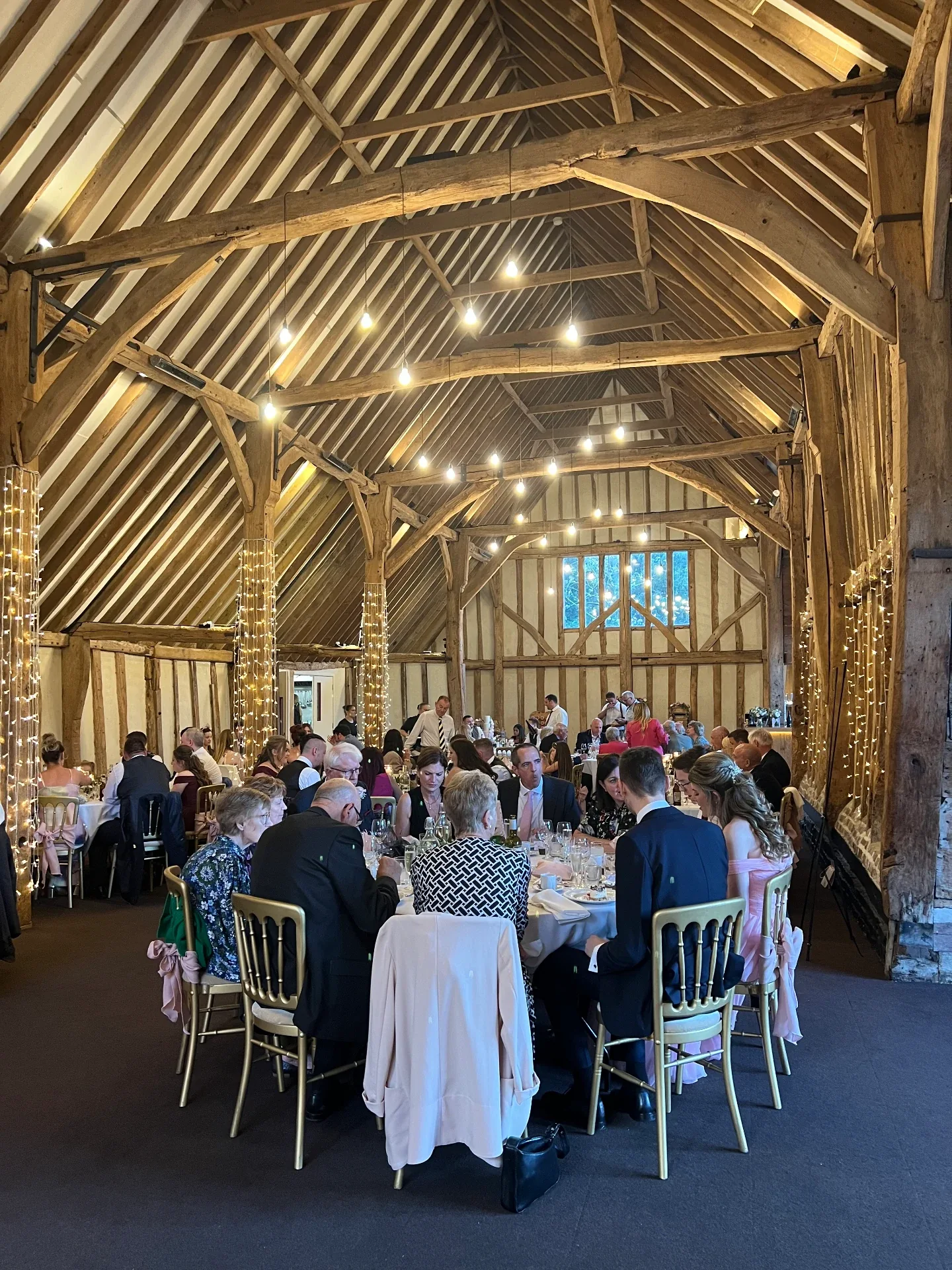 Wedding guests celebrating in a timber-framed barn