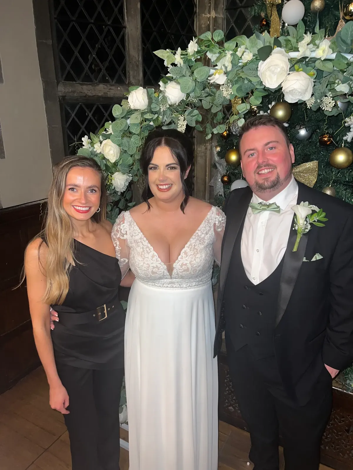 Sally Hall with a bride and groom at a winter wedding flower arch